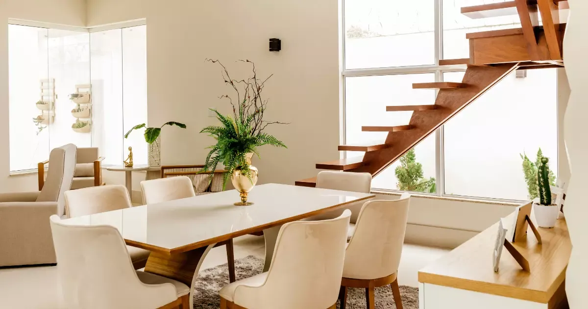 Bright dining room with natural light, plants, and wood finishes, inspired by current interior design trends