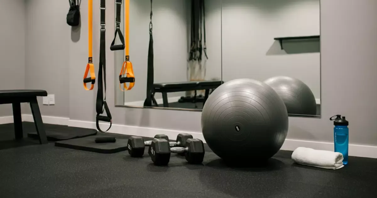 Compact home gym with TRX straps and dumbbells designed through basement remodeling