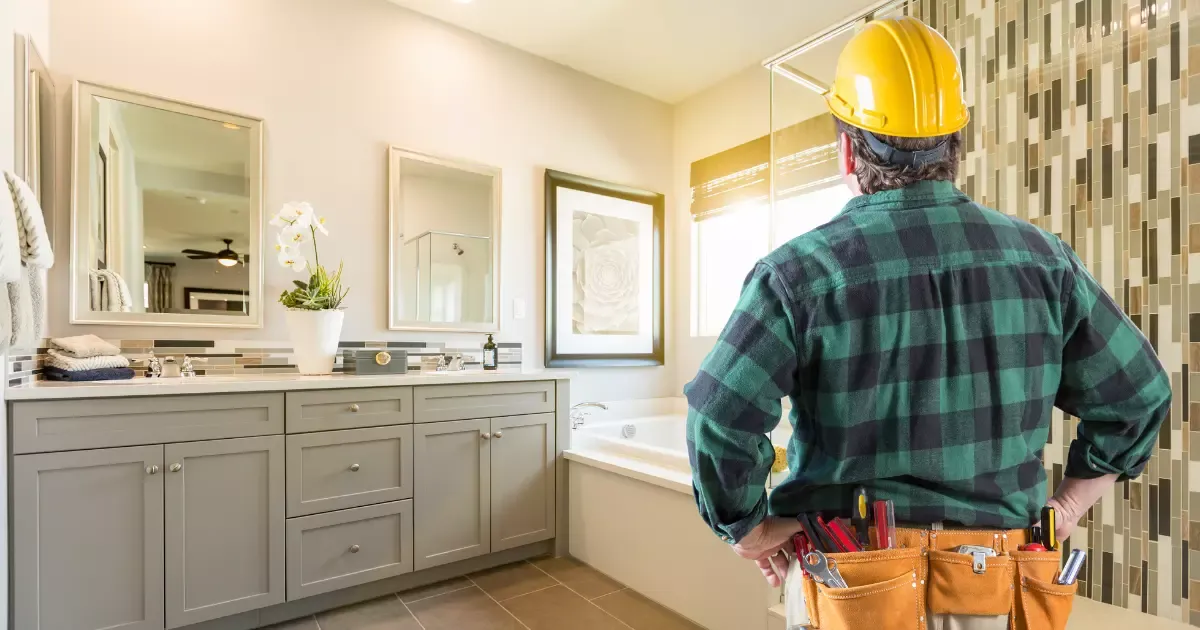 Contractor inspecting modern vanity and tub during bathroom remodeling project