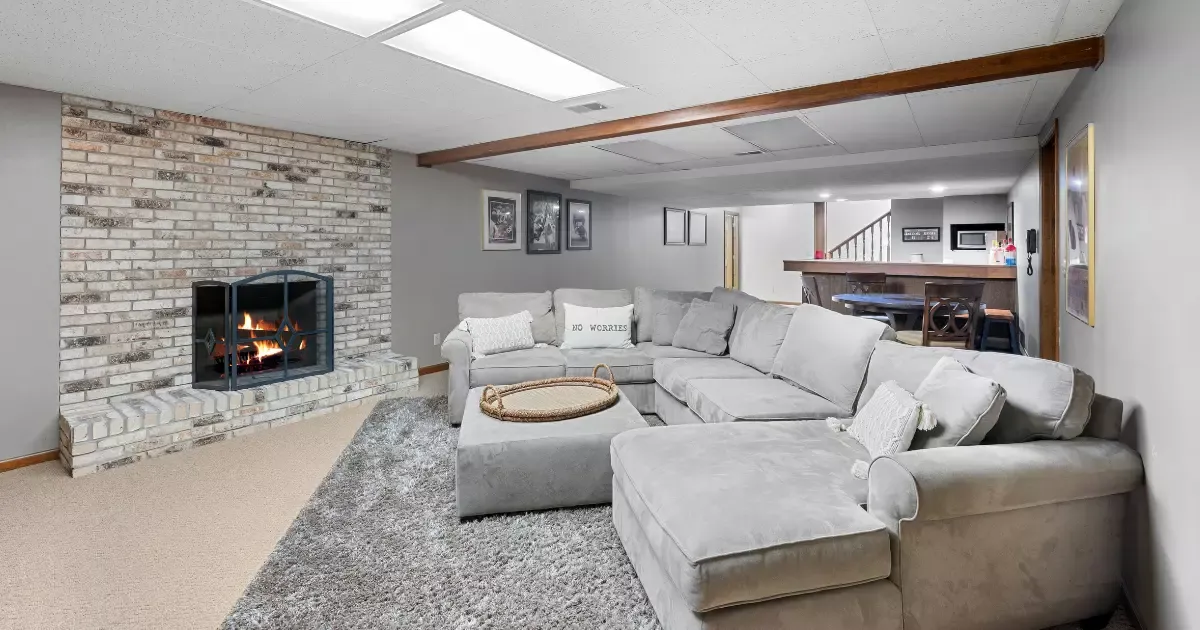 Cozy living area with fireplace and sectional sofa after basement remodeling project