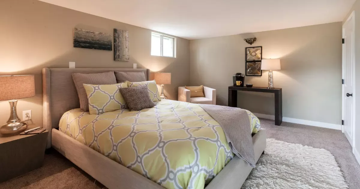 Cozy finished bedroom created through basement remodeling with soft lighting and modern decor