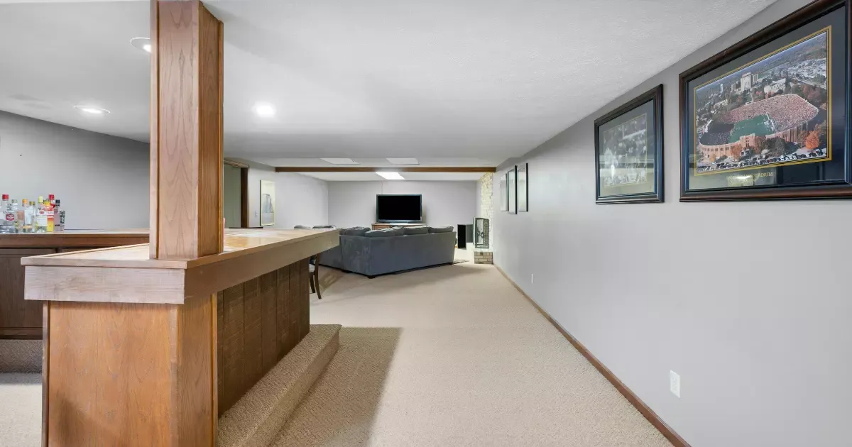 Basement finishing with bar area, carpet flooring, recessed lights, and cozy seating space for entertainment
