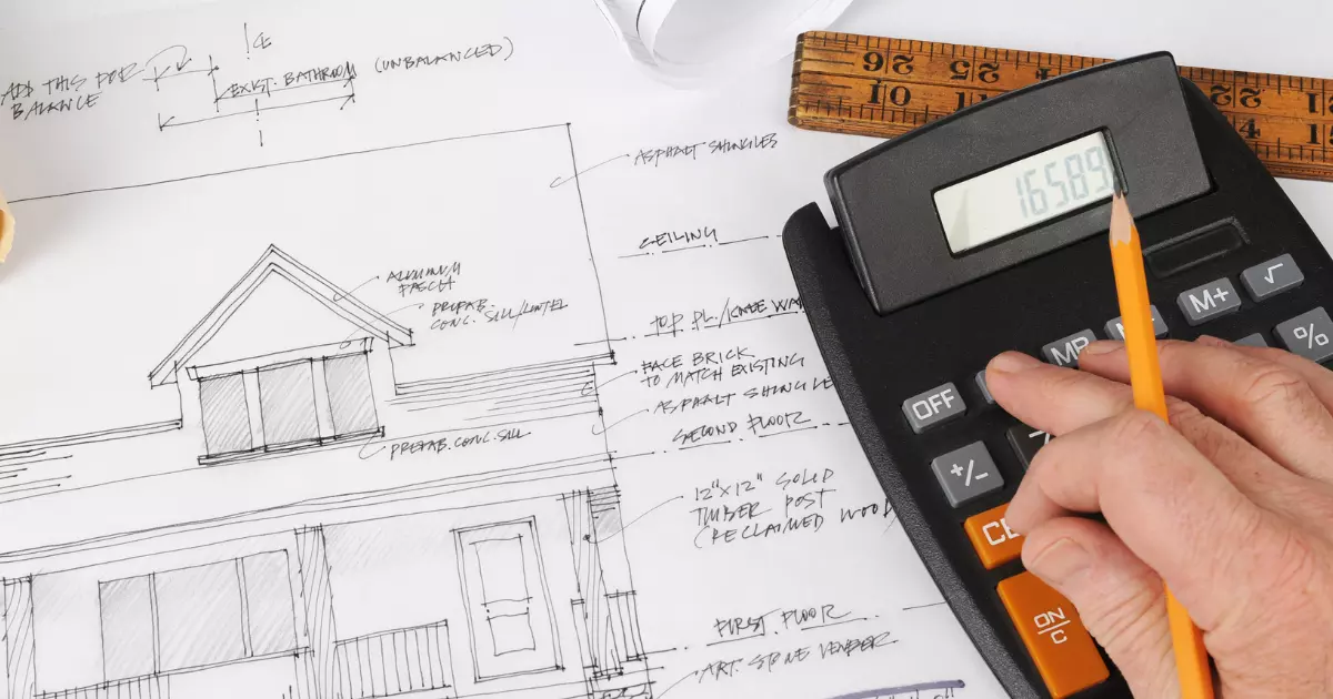 Person calculating costs on a home blueprint with calculator and ruler, planning a home addition project budget
