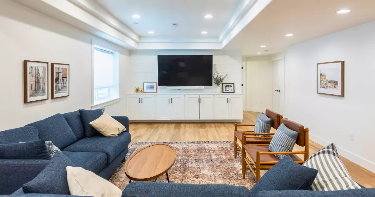 Cozy modern living area with built-in cabinets and recessed lighting, highlighting expert basement finishing