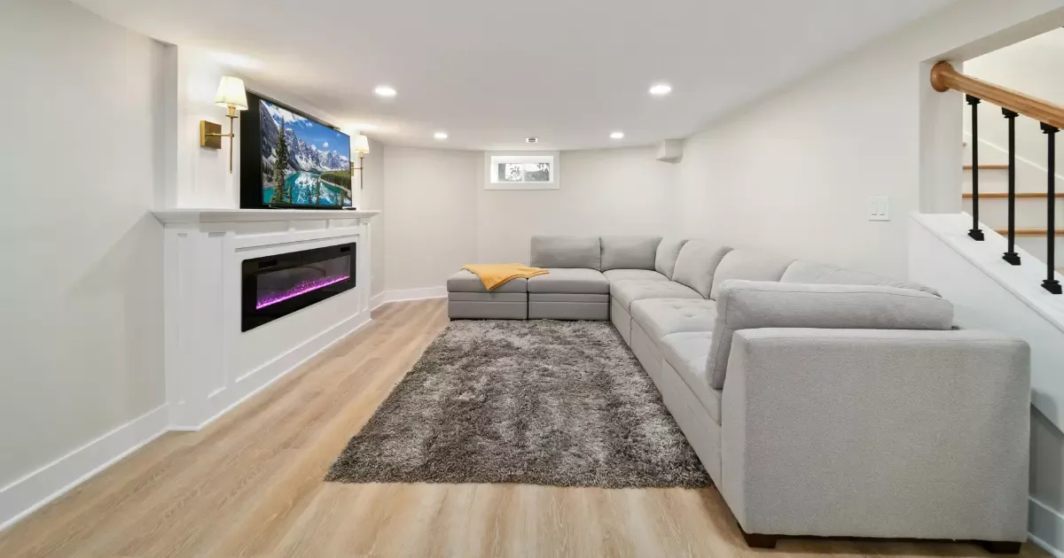 Modern finished basement with sectional sofa and fireplace, showcasing basement remodeling ideas