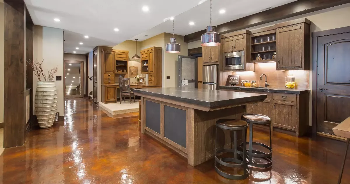 Basement remodeling with modern wet bar, large island, wood cabinetry, and polished concrete floors