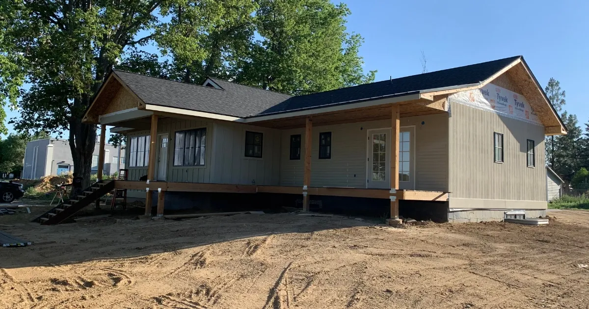 Side view of a partially completed residence highlighting framing and exterior work in custom home building