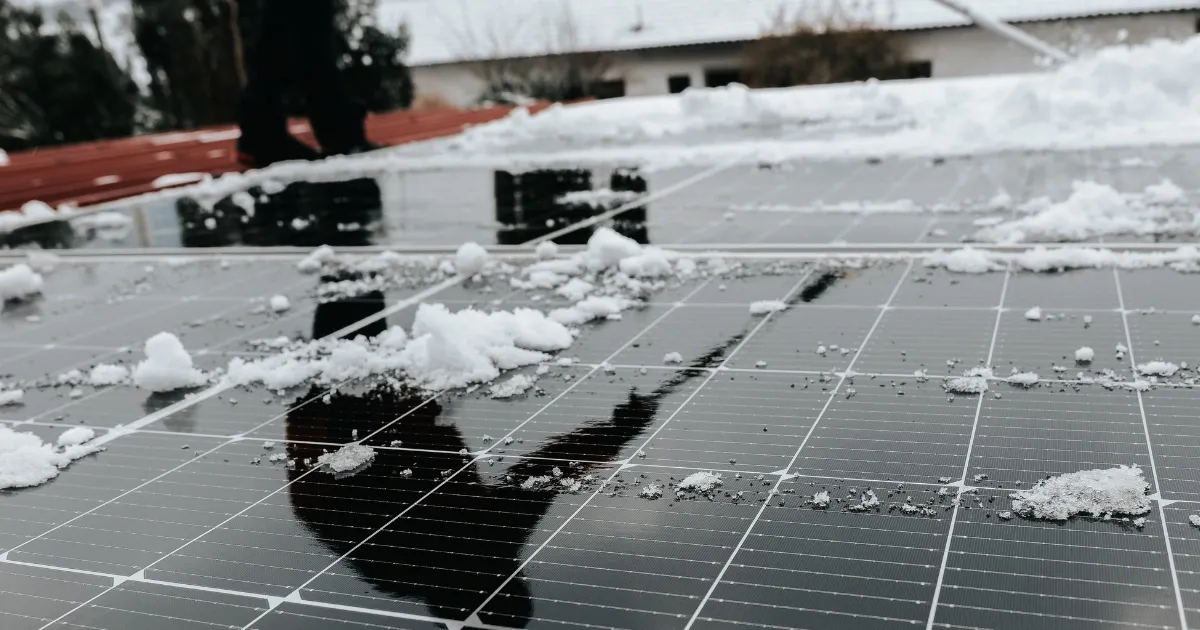 Snow on rooftop panels showing need for cleaning solar panels in winter