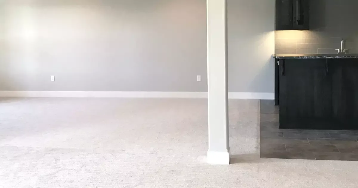Modern open space with carpet and bar area highlighting professional basement finishing remodel design