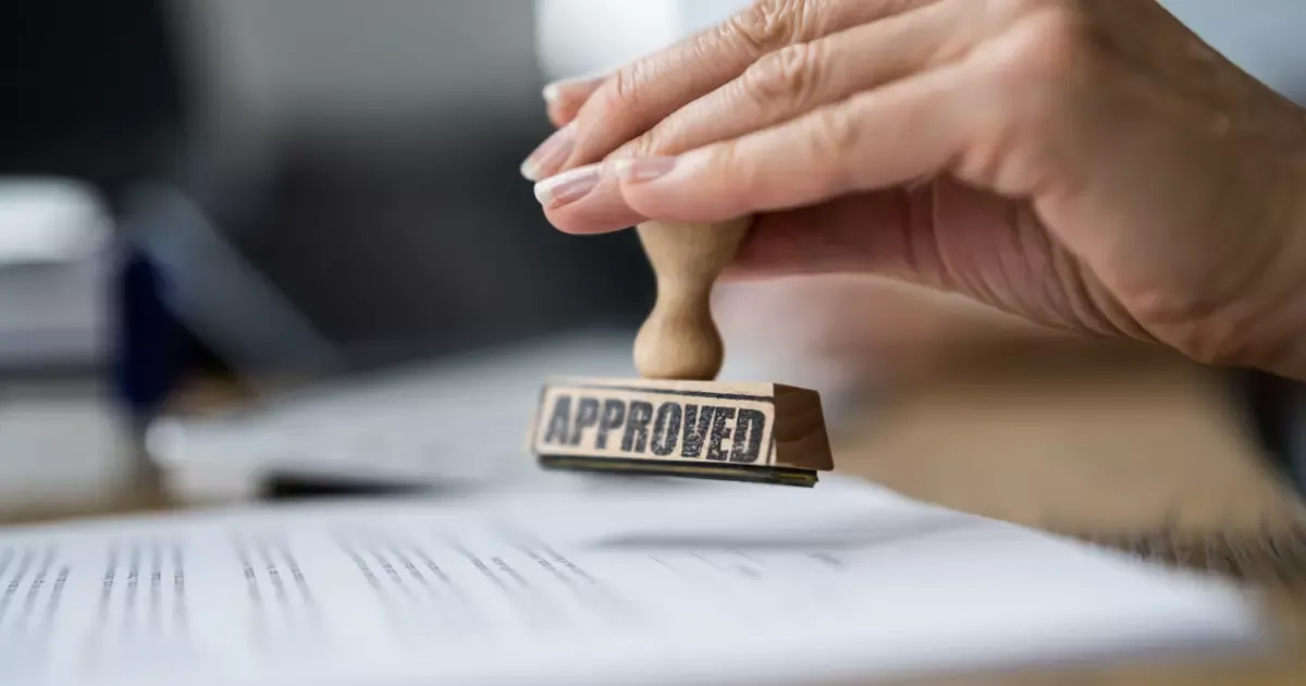 Hand stamping approved permit paperwork for a basement remodeling project