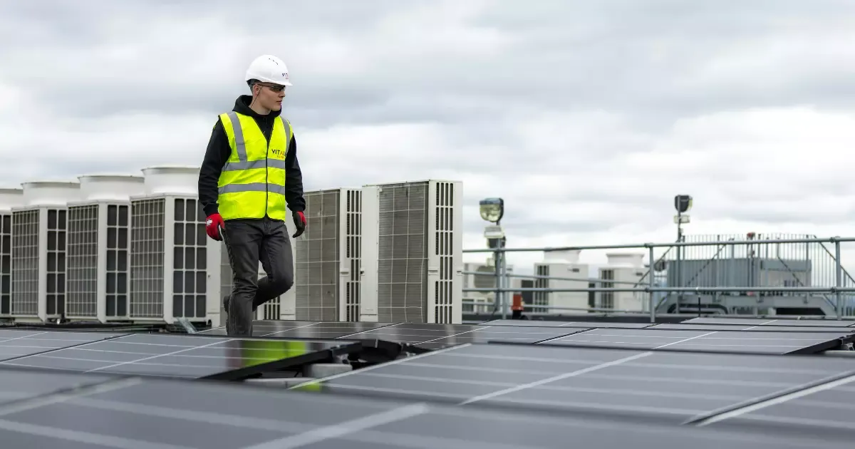 Technician inspecting commercial solar panels installed on a flat rooftop to ensure optimal performance.