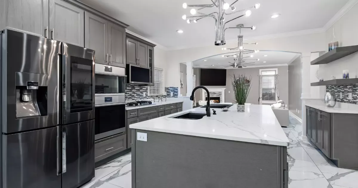 Modern gray kitchen with large island and stainless appliances by kitchen remodeler near me
