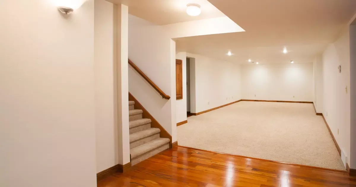 Basement finishing with recessed lighting, carpeted floor, wood trim, and stairs leading to bright open space