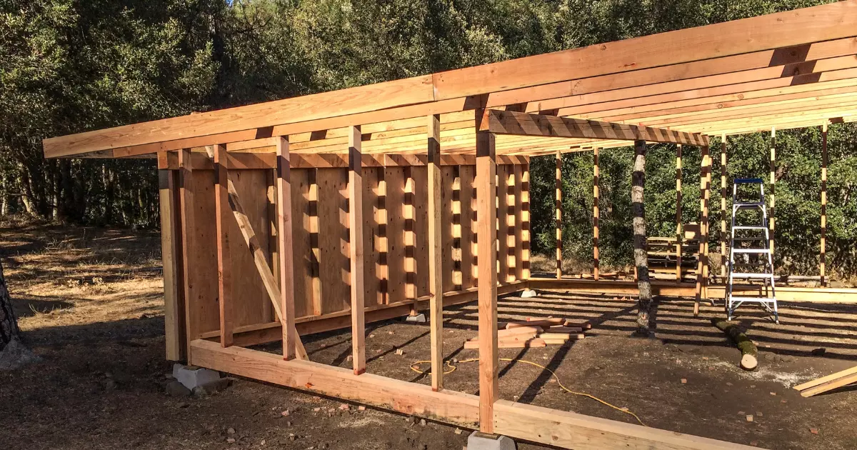 Wooden frame structure under construction on foundation blocks in outdoor home construction site