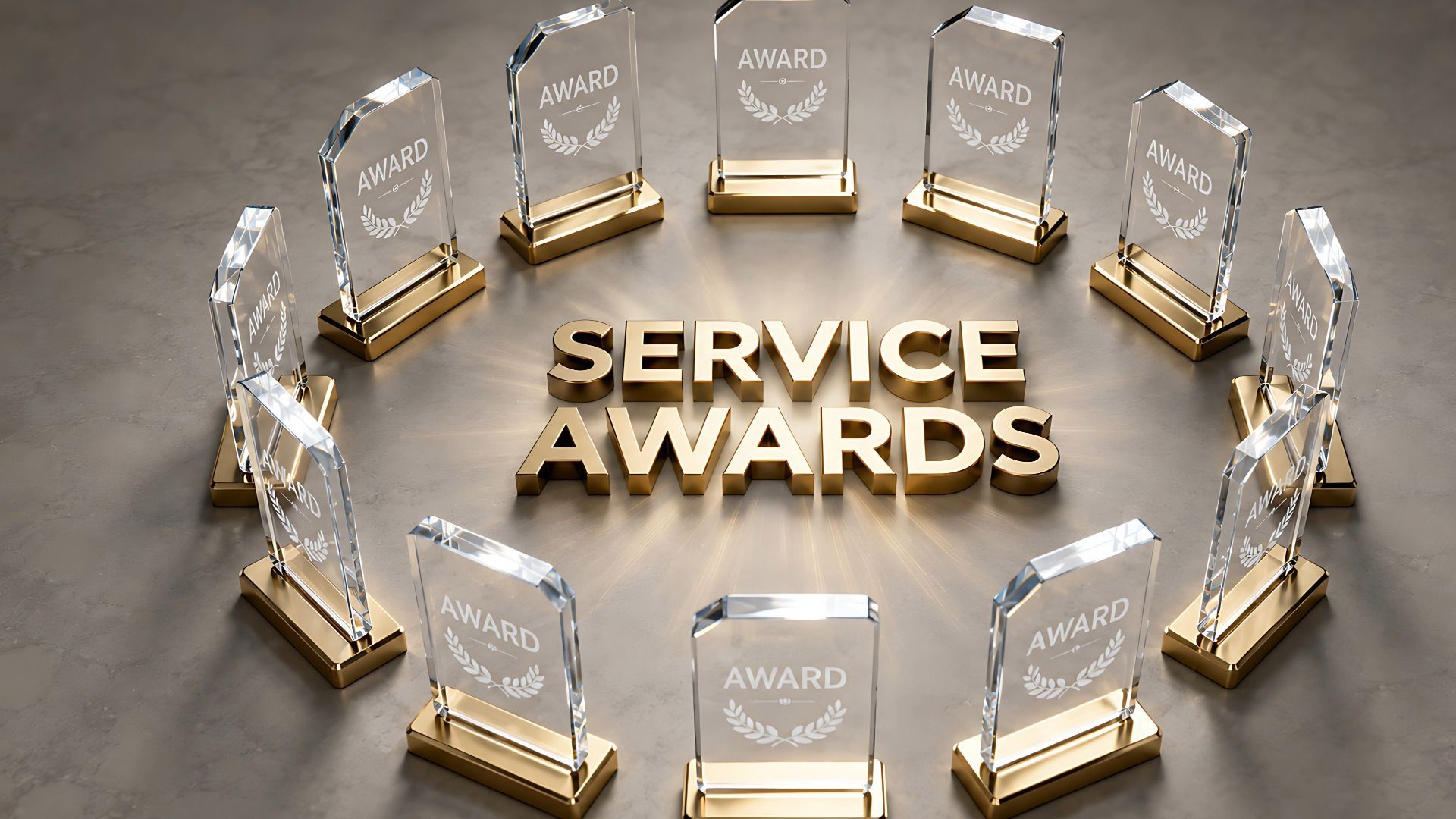 Service awards trophies arranged in a circle around gold lettering on a gray surface