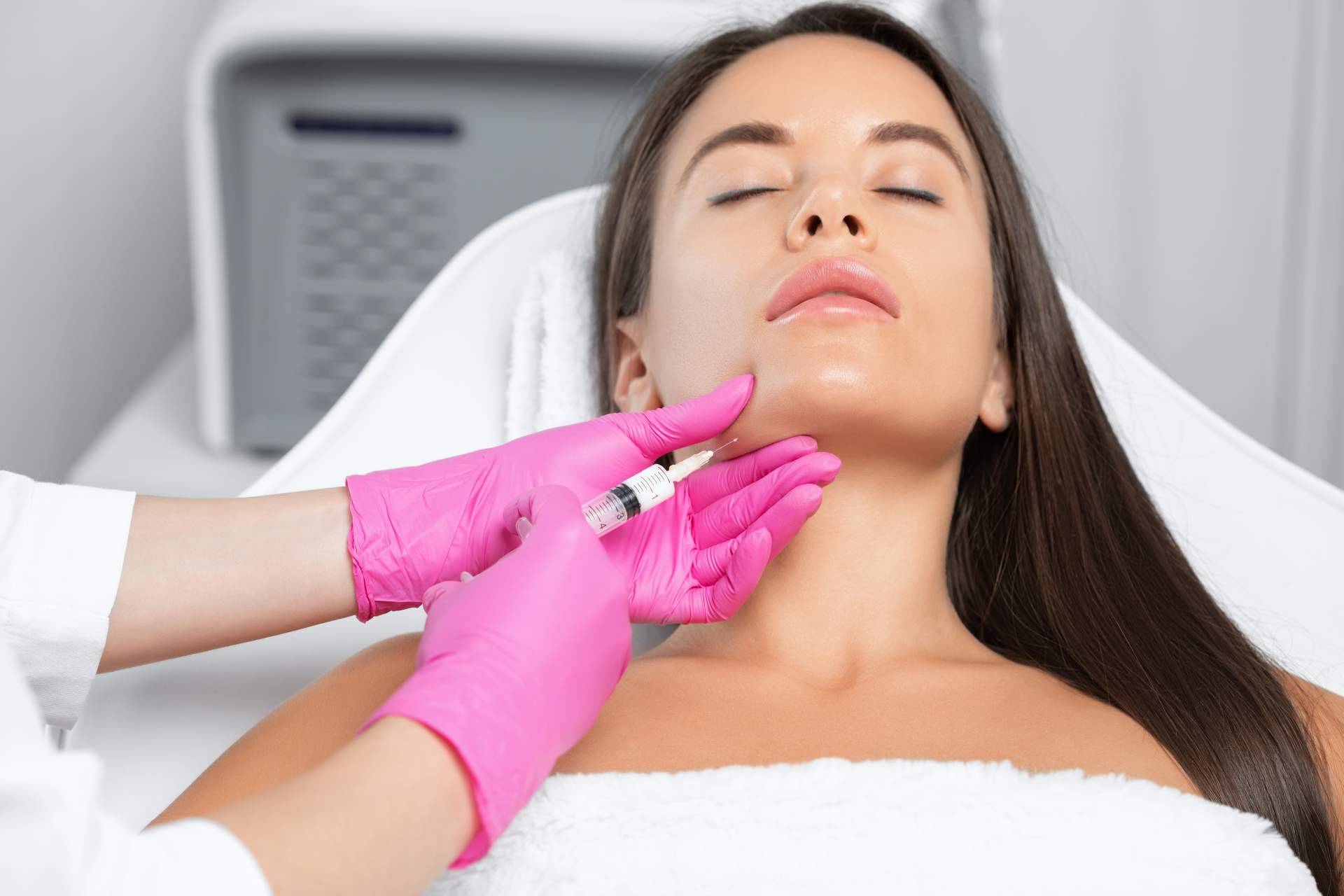 A woman is getting a botox injection in her face.