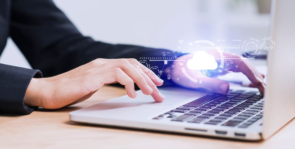 A person is typing on a laptop computer.