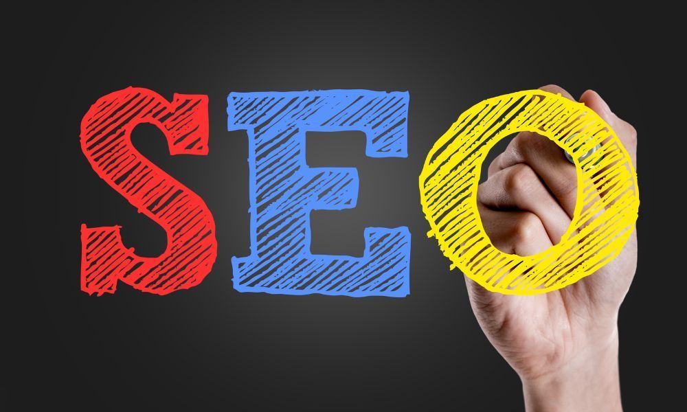 A hand is writing the word seo with a marker