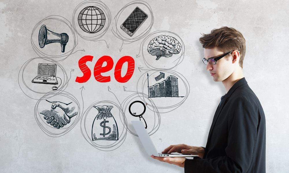 A man is using a laptop computer in front of a whiteboard with the word seo written on it.