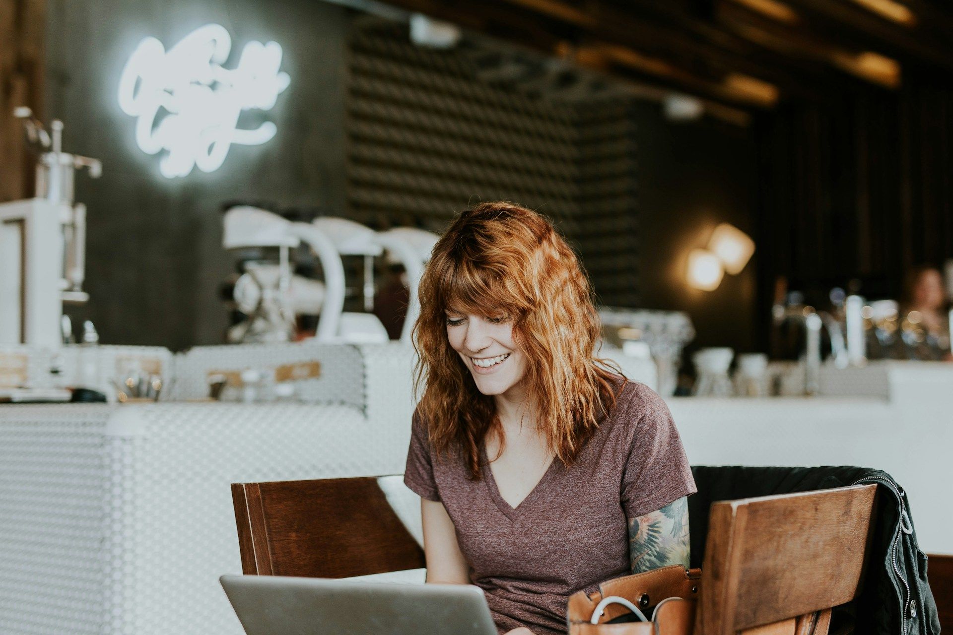 A woman is sitting at a table using a laptop computer.