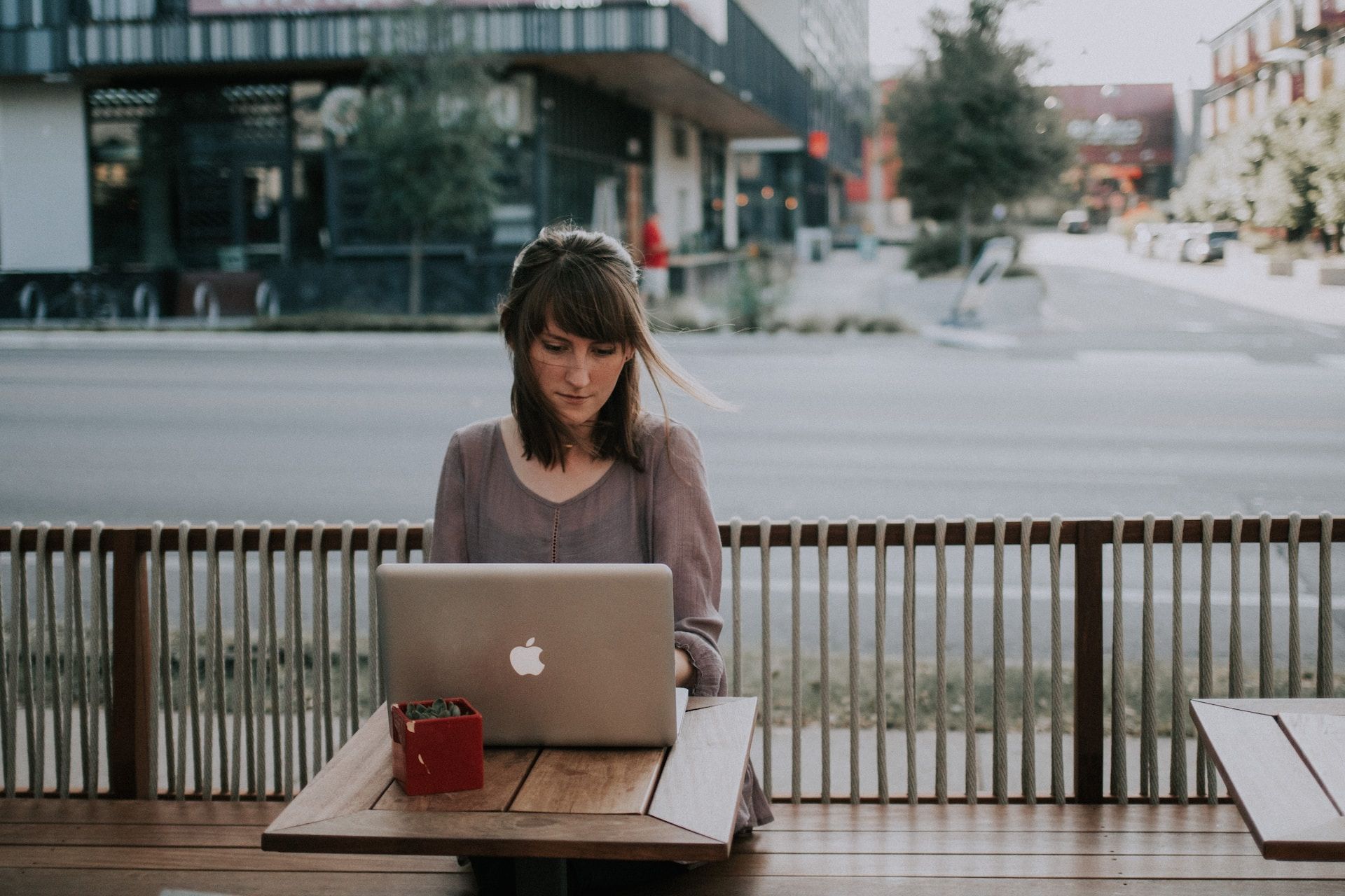A woman is sitting at a table using a laptop computer.