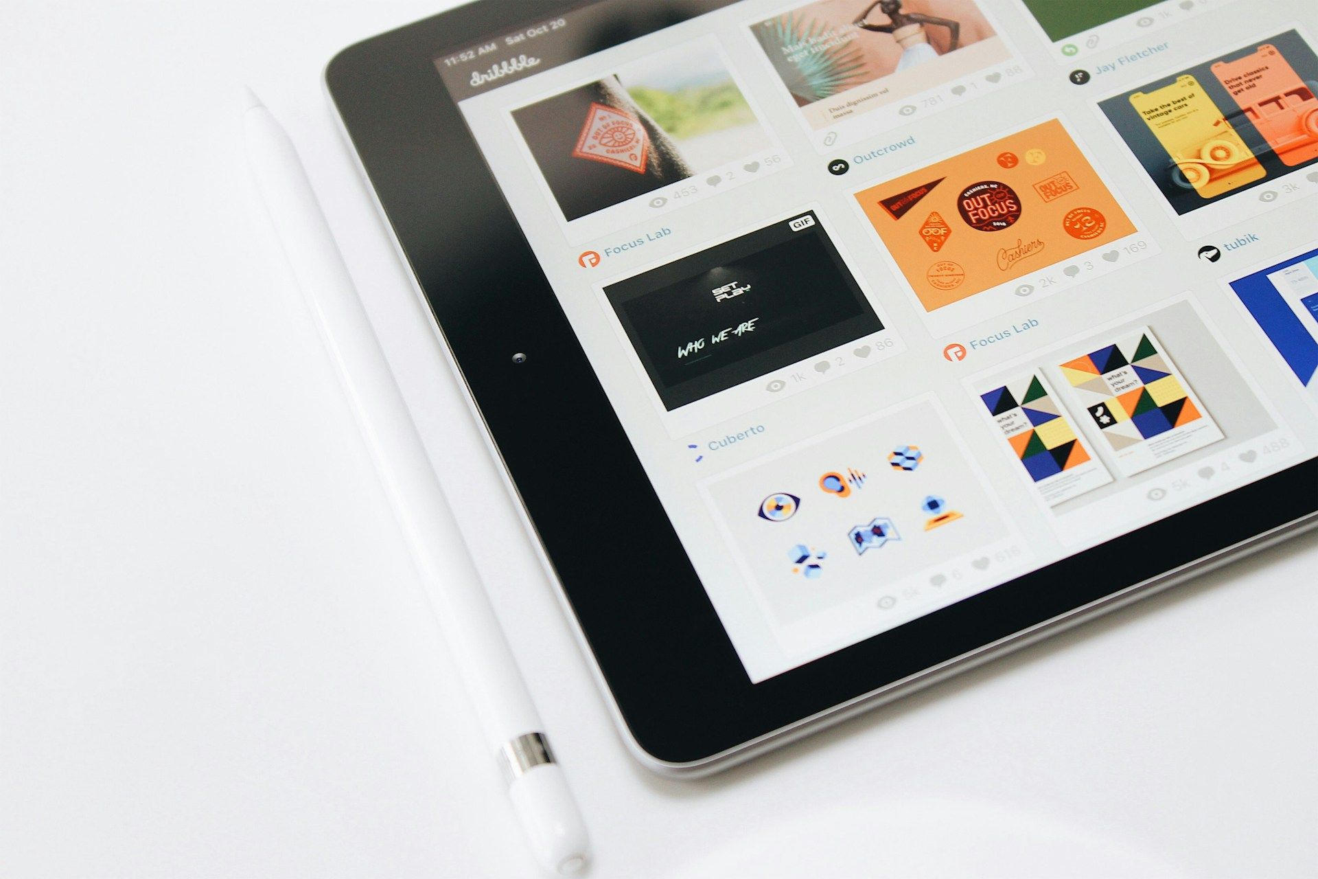 A tablet is sitting on a table next to a pen.