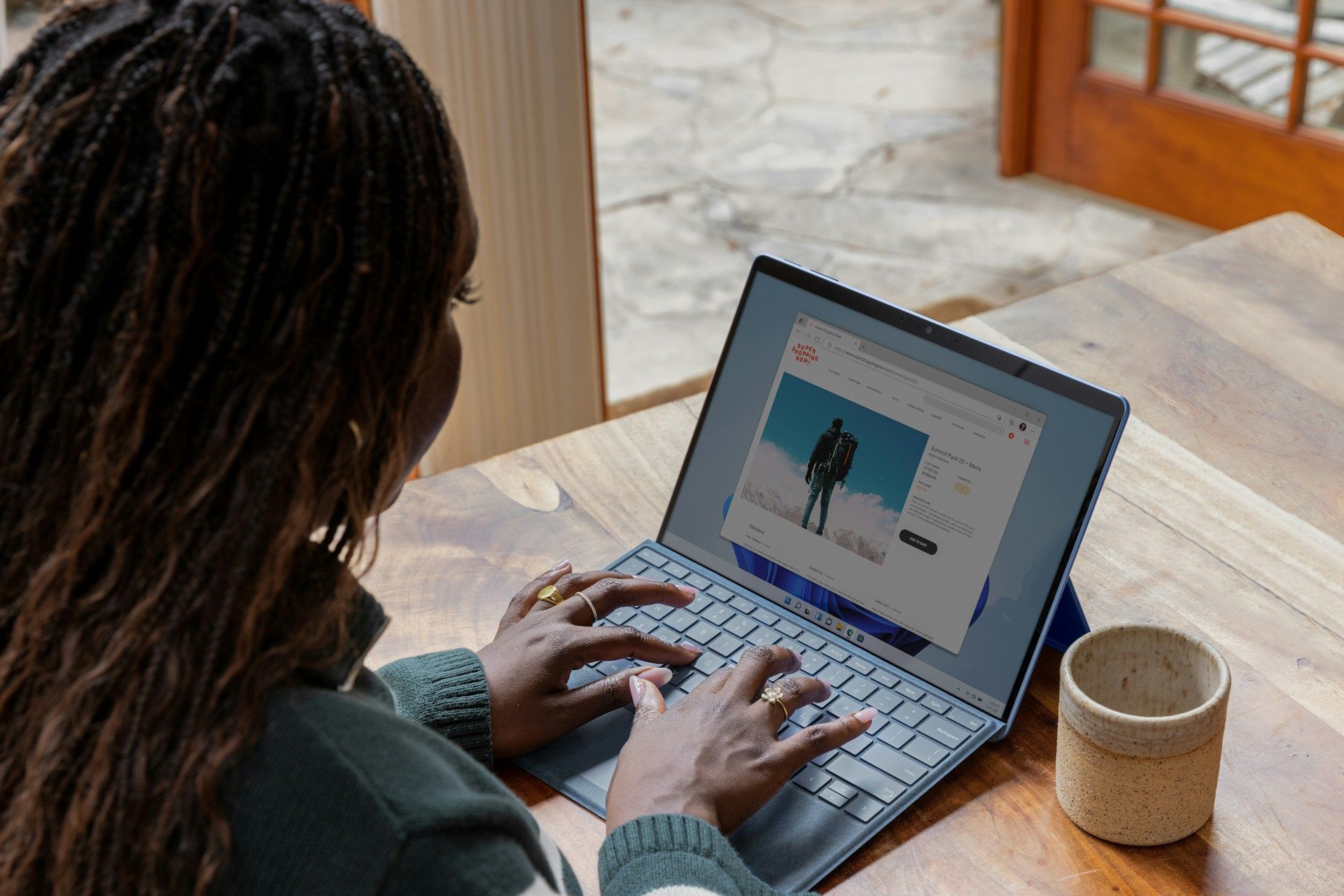 A woman is sitting at a table using a laptop computer.
