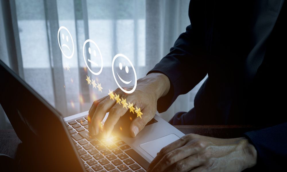 A person is typing on a laptop computer with smiley faces and stars coming out of it.