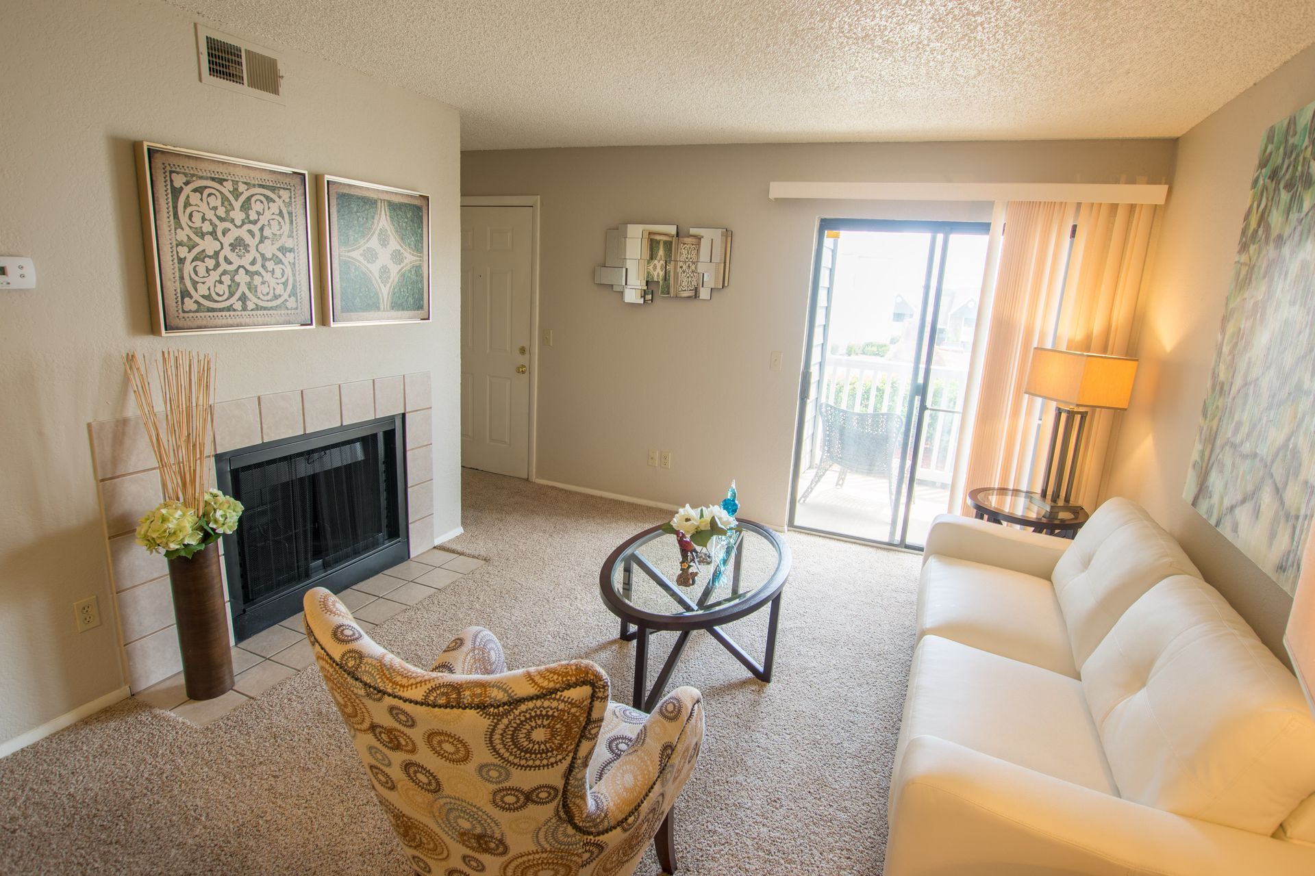 A living room with a couch , chair , coffee table and fireplace.