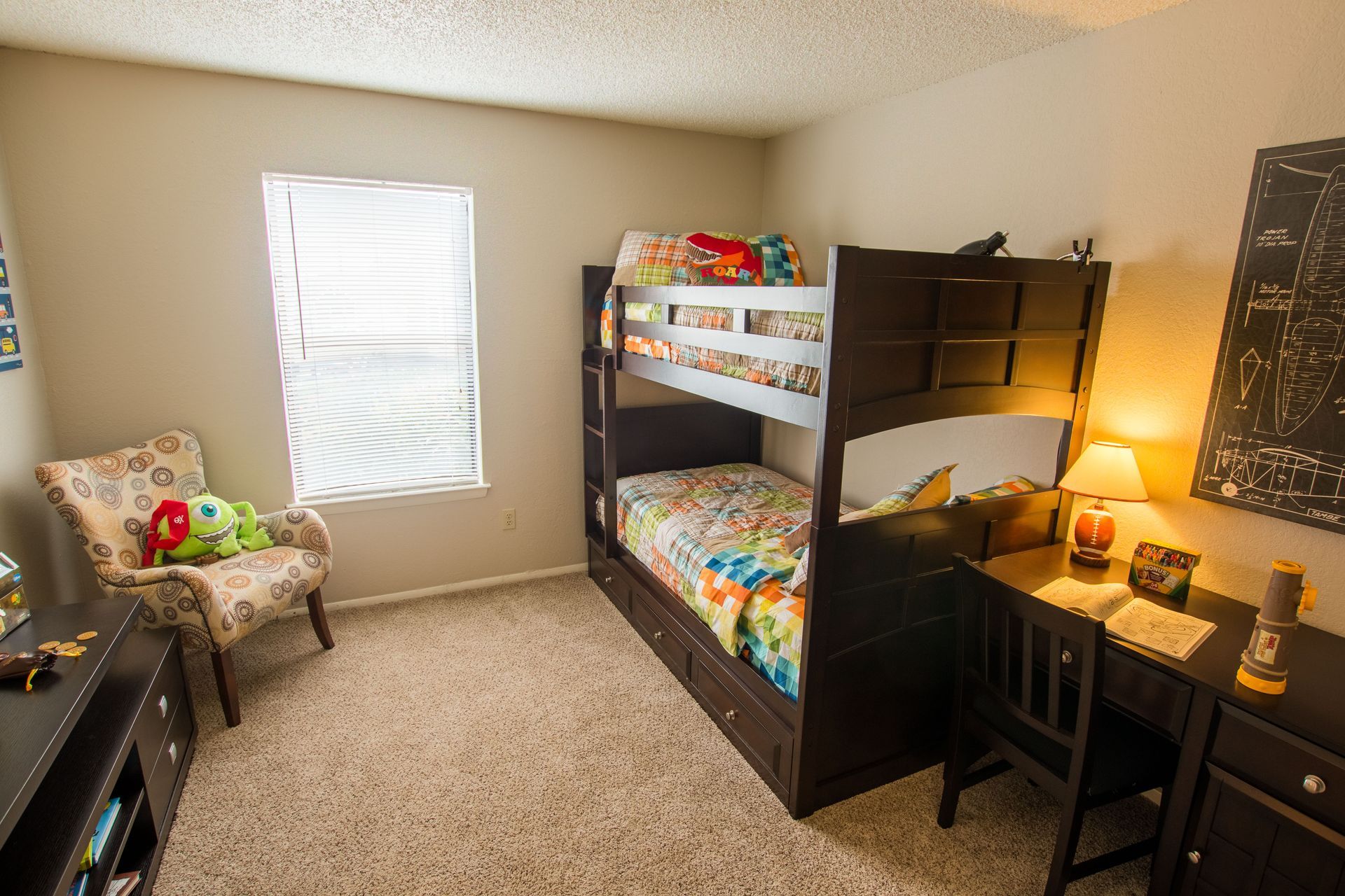 A bedroom with a bunk bed and a desk