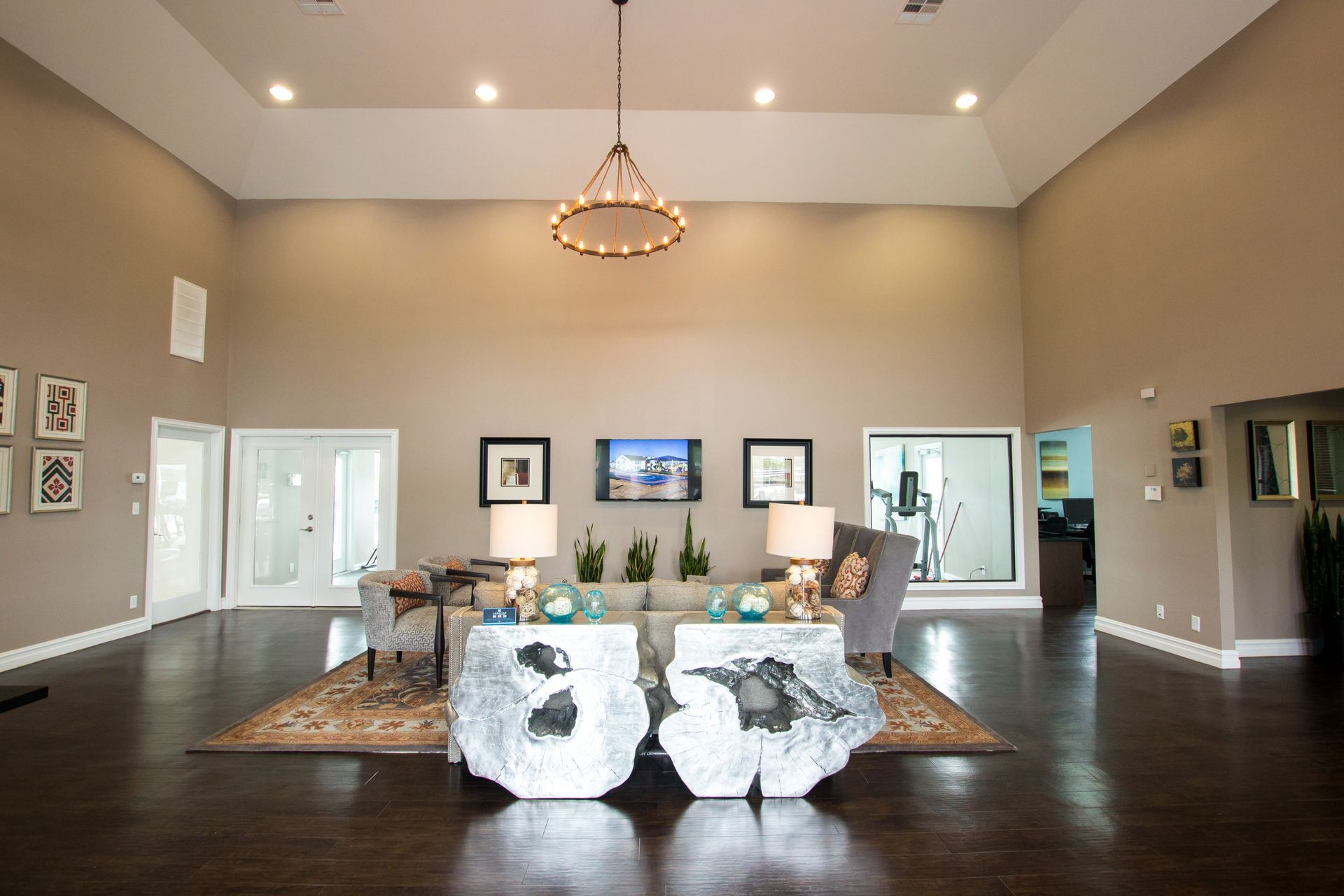 A living room with two tables and a television on the wall