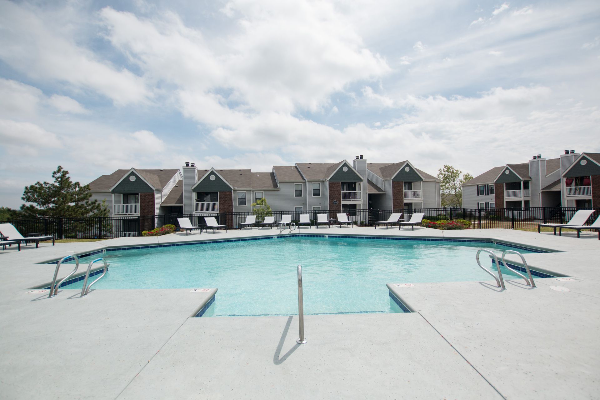 A large swimming pool in front of a row of houses