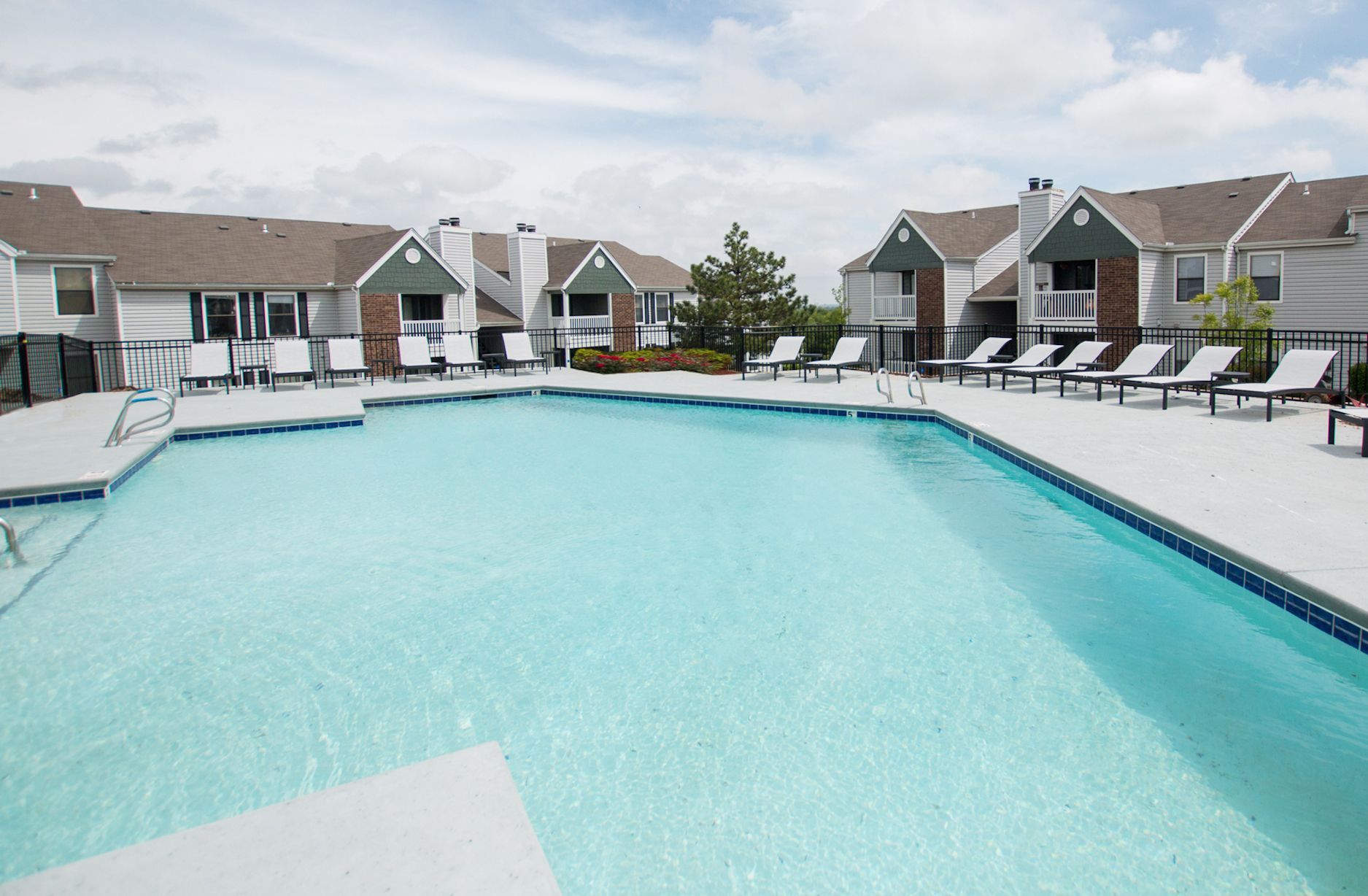 A large swimming pool in front of a row of houses