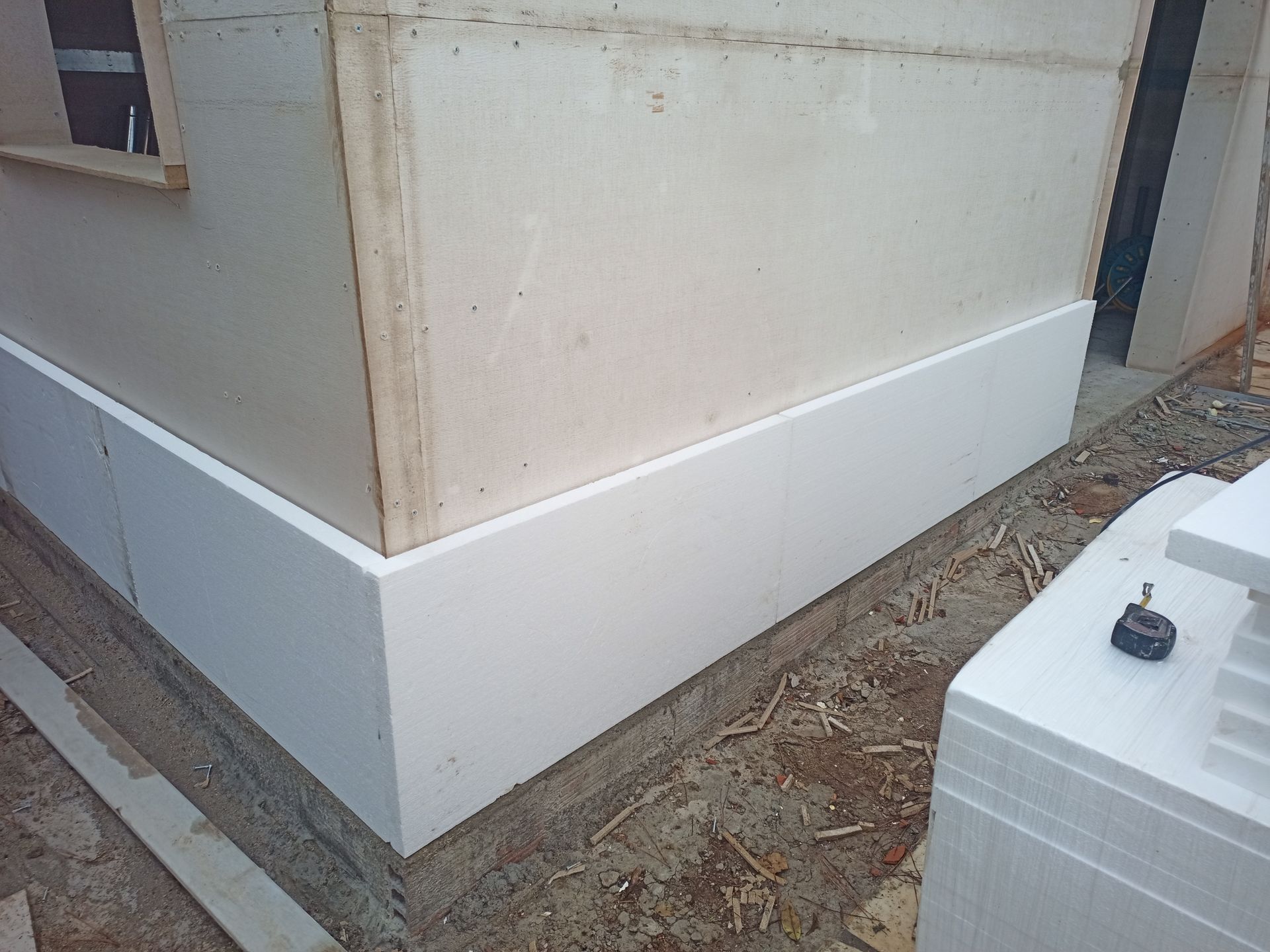 Isolamento de espuma branca instalado no canto externo de um prédio em construção.