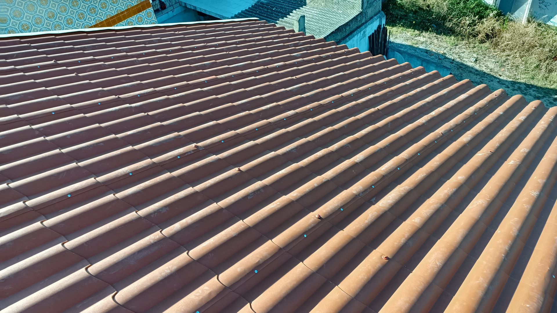 Telhas onduladas marrons na parte externa de um edifício.