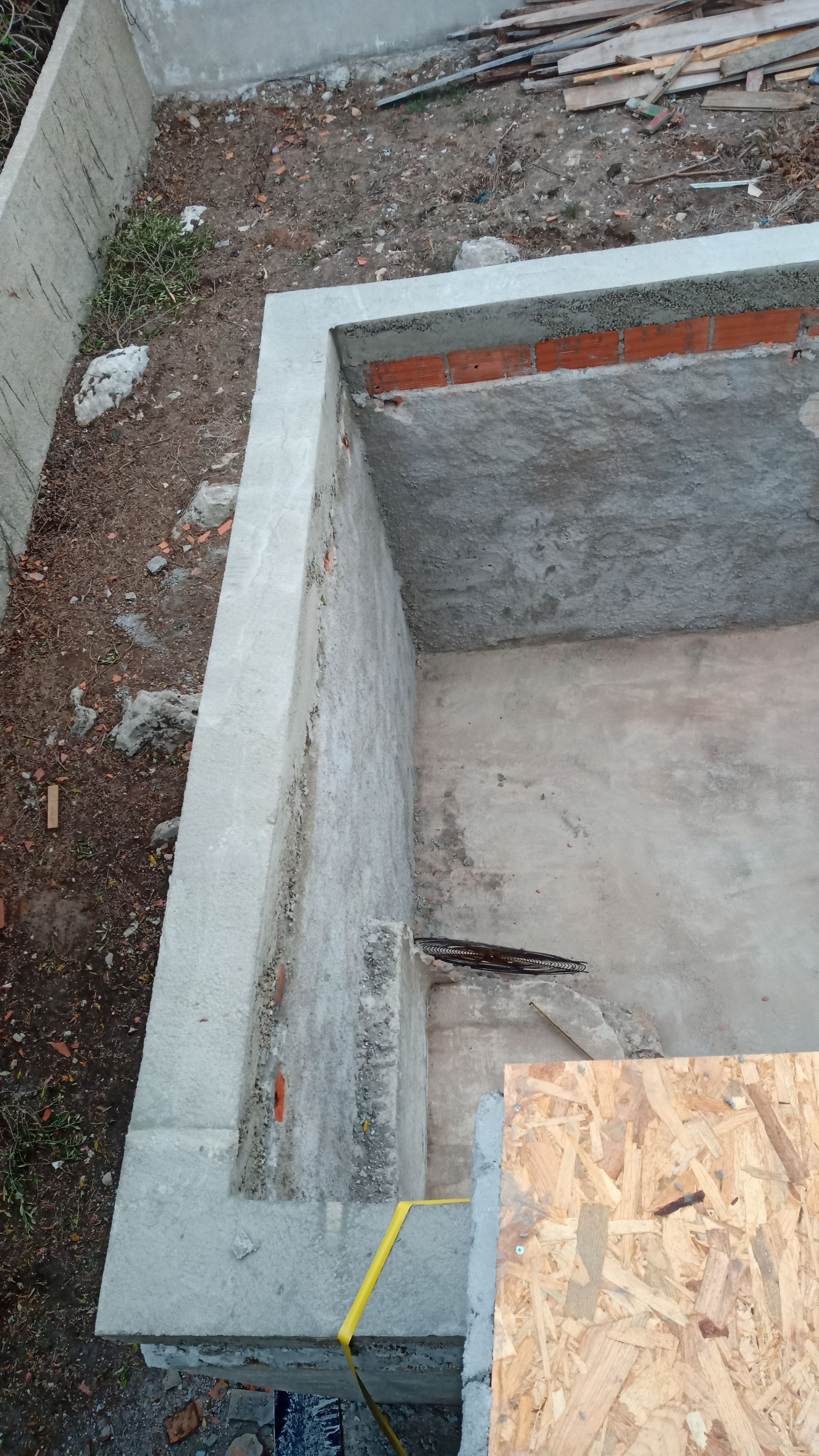 Paredes e piso de fundação em concreto; canteiro de obras.