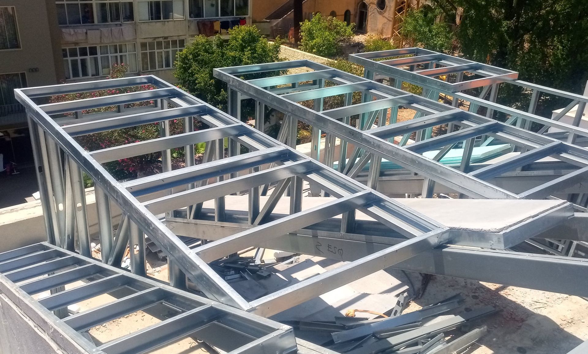 Estrutura metálica para construção de telhado em um edifício, exposta à luz solar direta.
