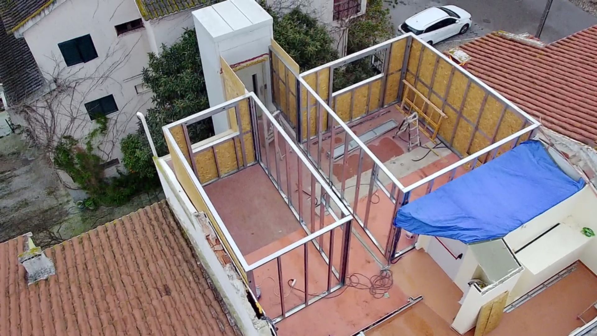 Construção da estrutura interna de um edifício em um telhado. As paredes são parcialmente construídas com madeira e metal.