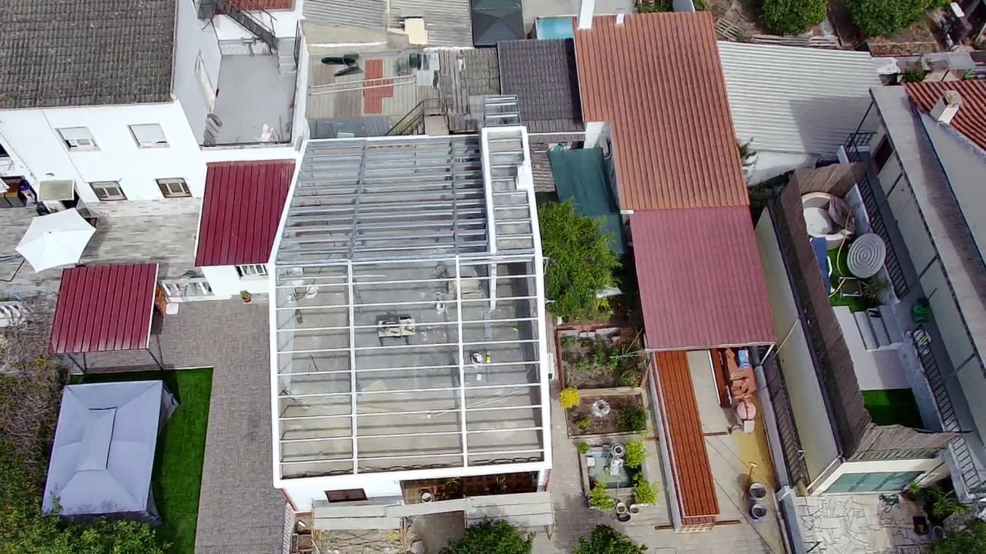 Vista aérea de edifícios com telhados de cores variadas e um pátio.