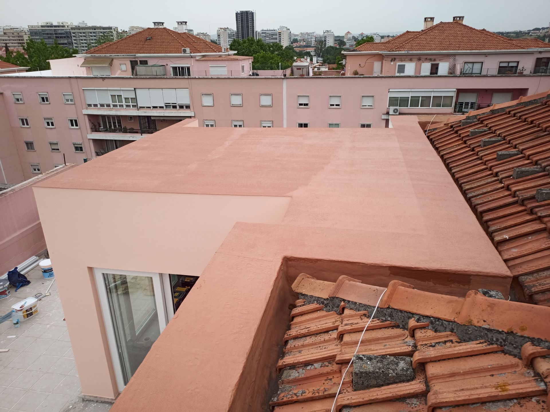 Telhado plano rosa e telhado de telha em edifícios em ambiente urbano.