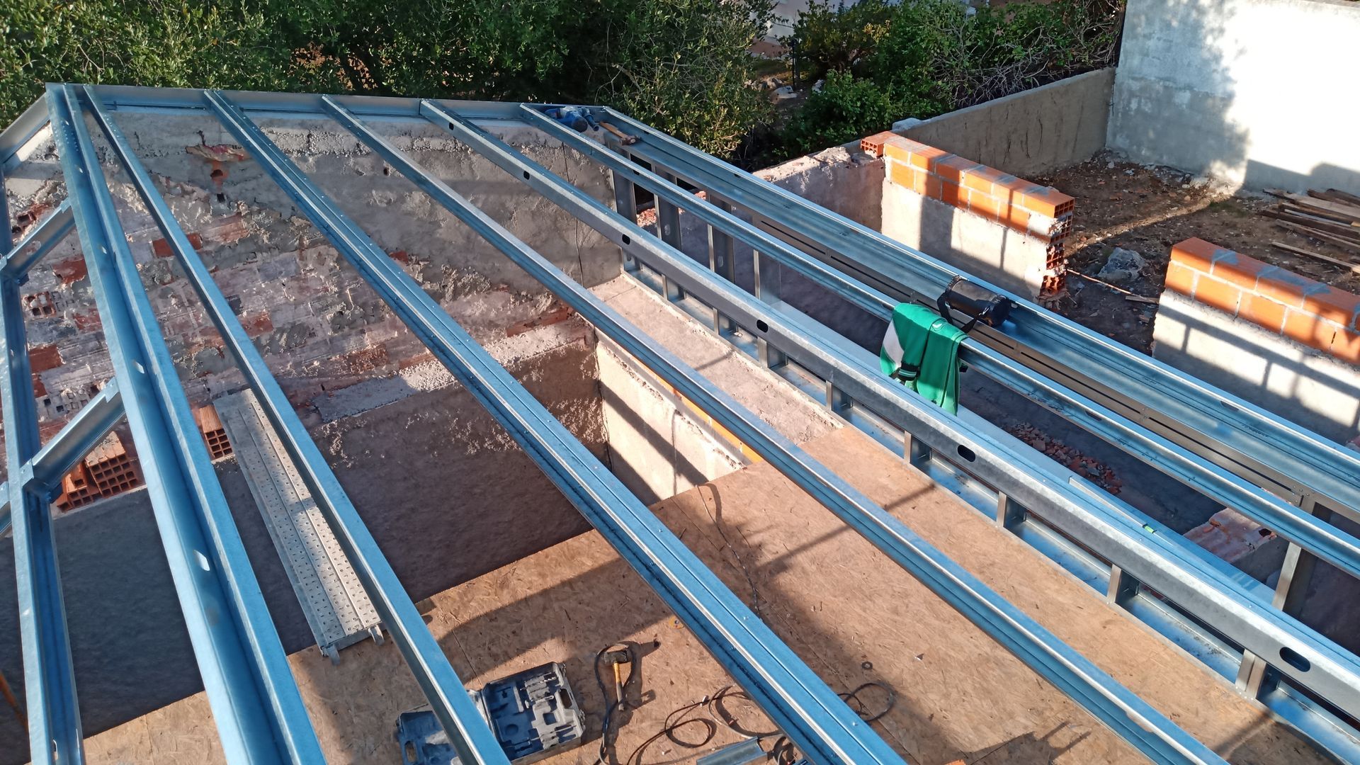 Instalação da estrutura metálica do telhado de um edifício em construção.