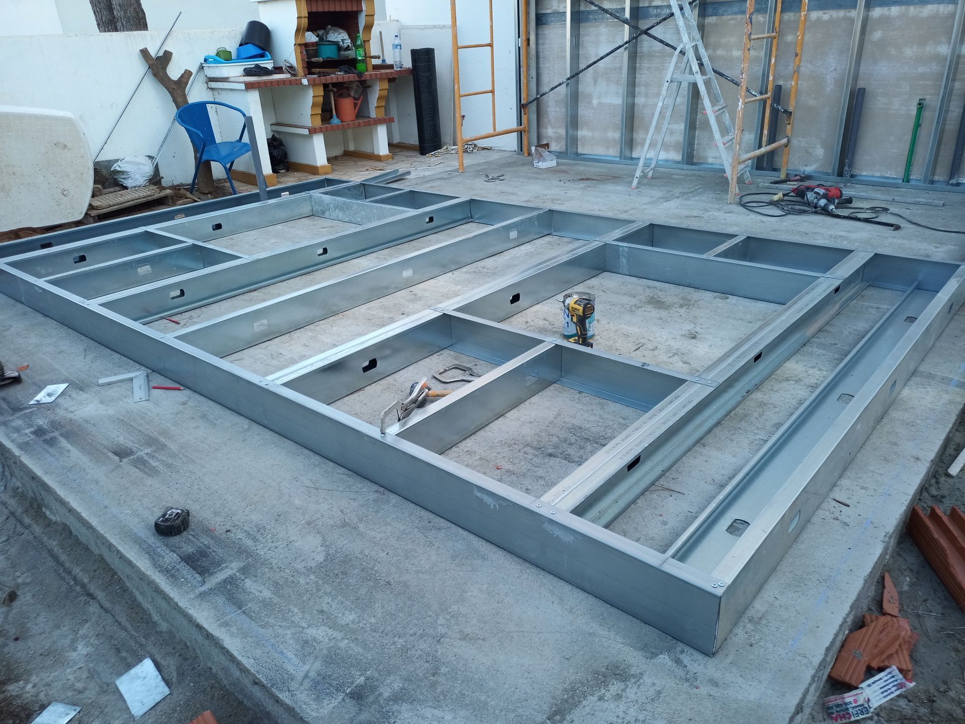 Estrutura metálica para o piso de um edifício assentada sobre uma laje de concreto; construção em andamento.
