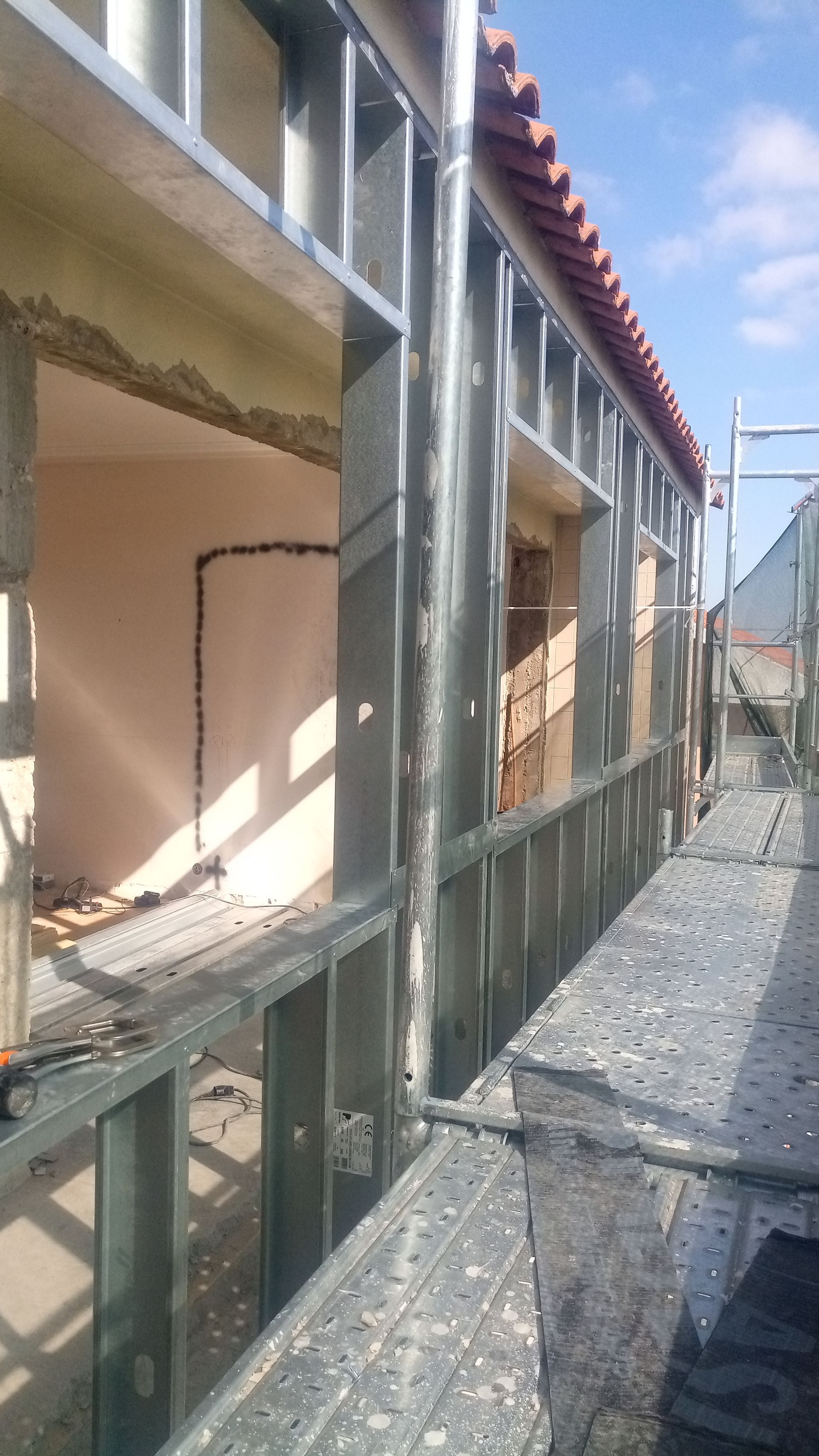 Construção exterior: estrutura metálica em torno das janelas, presença de andaimes.