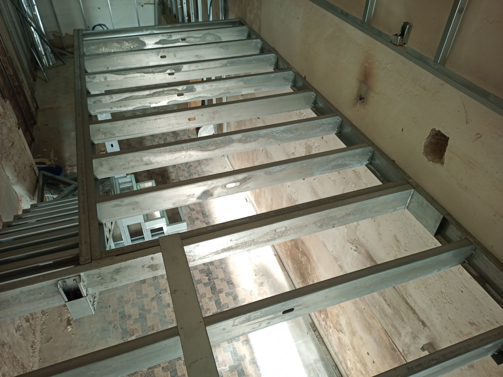 Escada metálica em construção, com degraus de concreto e estrutura aparente.