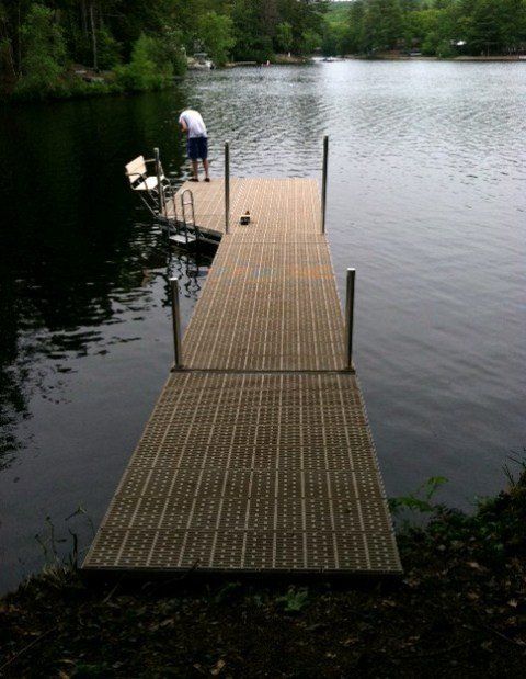 a man is standing on a dock overlooking a lake