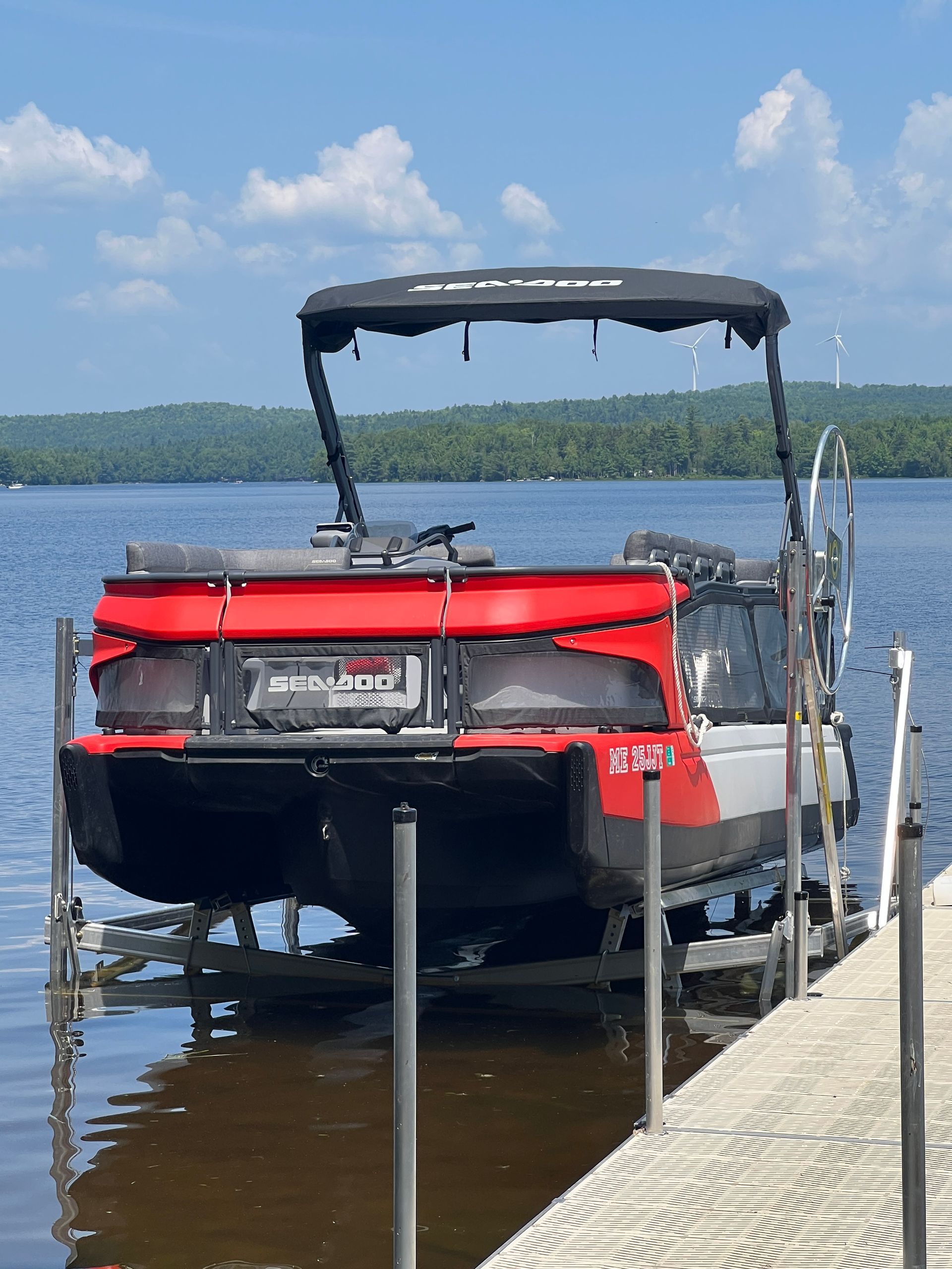 A pontoon boat is docked at a dock on a lake