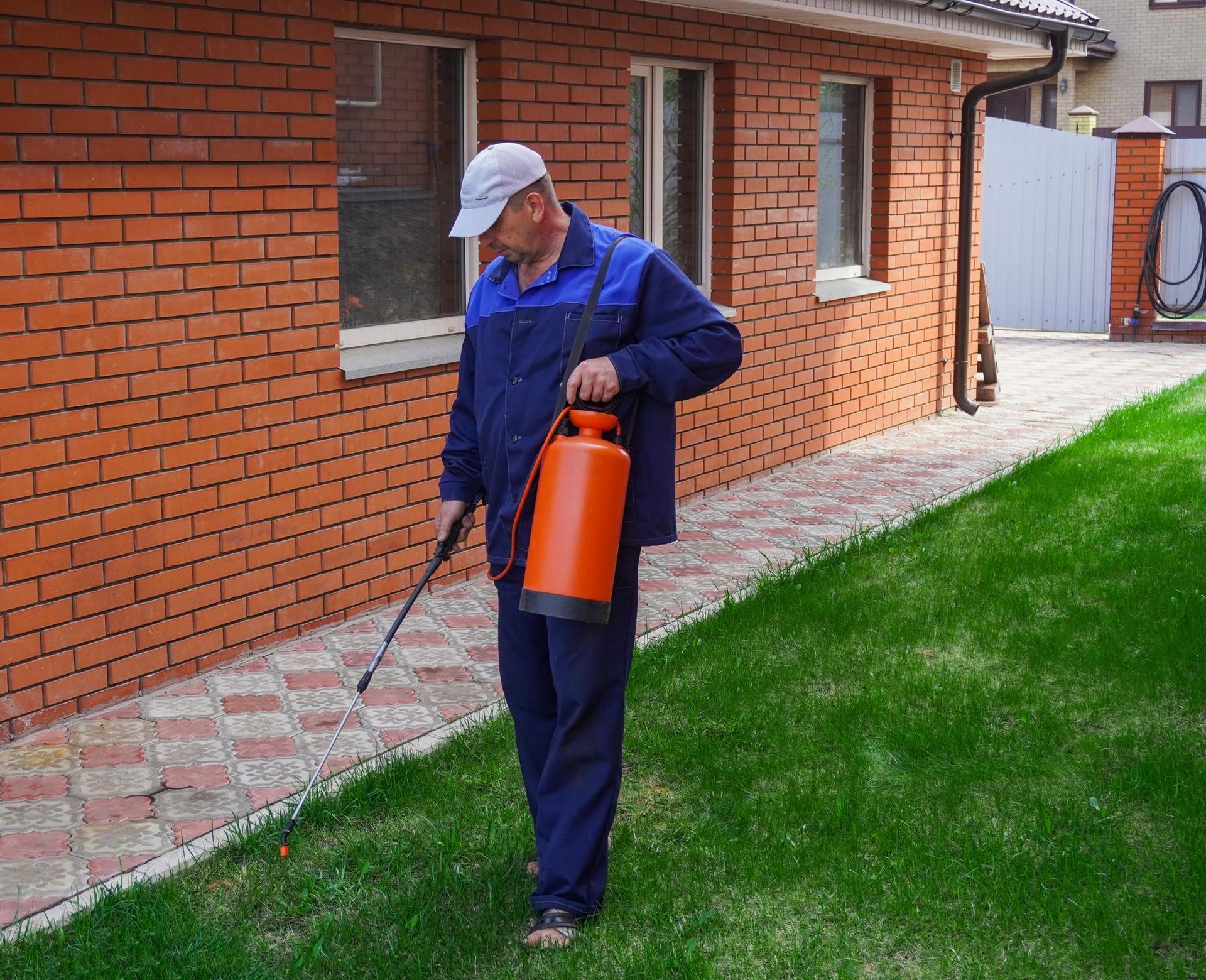 General pest control technician spraying home exterior