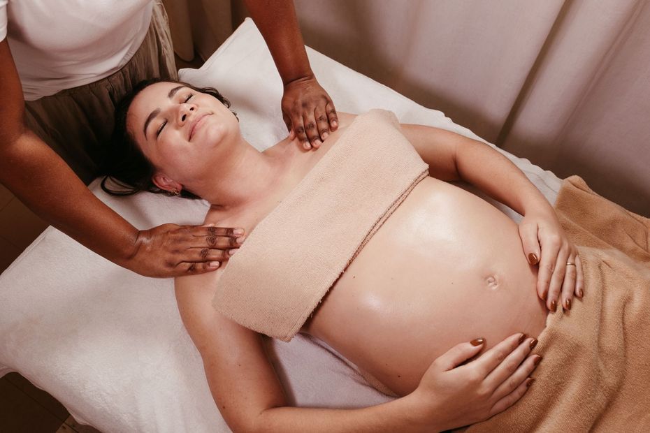 Massage therapist giving a prenatal massage to a pregnant woman on a table