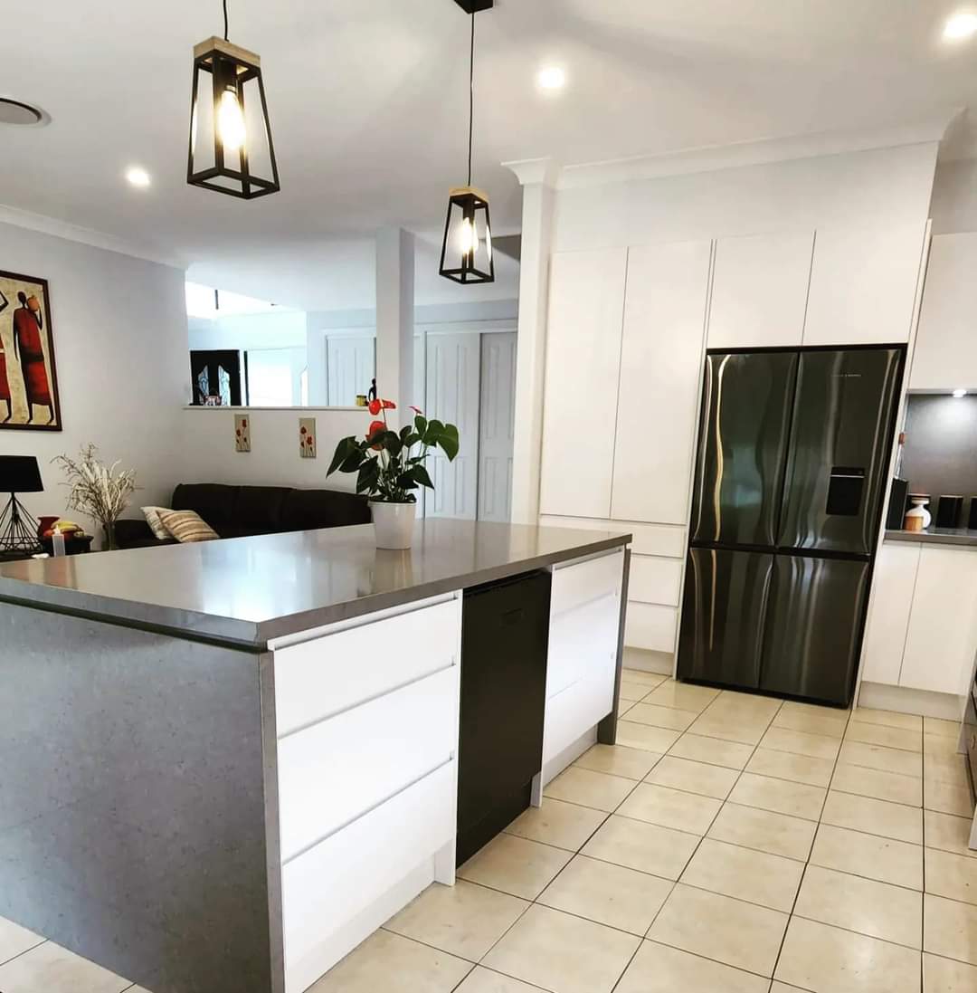 Grey Stone Kitchen Island With Large White Drawers And Matte Dishwasher — DMB Kitchens in Port Macquarie, NSW