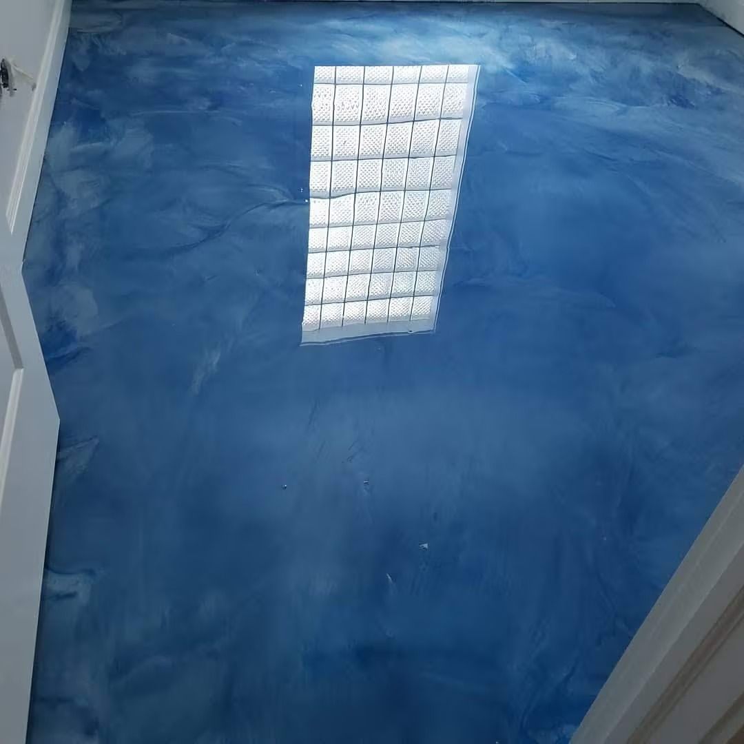 Blue epoxy floor with light reflection from a skylight.